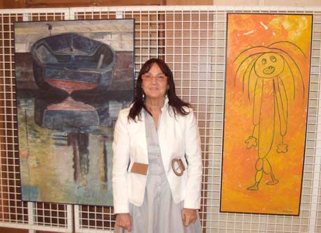 Loli Lucas con dos de las obras que expone en el Faro de Roquetas