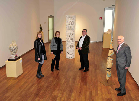 Los responsables de la exposición posan junto a varias de las obras.