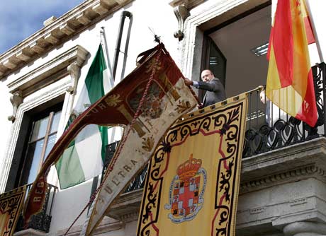 El alcalde de la ciudad colocando el Pendón en el balcón de la Casa Consistorial.