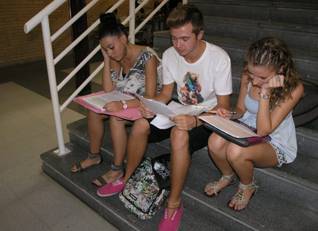 Tres alumnos dan el último repaso a los apuntes antes de entrar al examen.