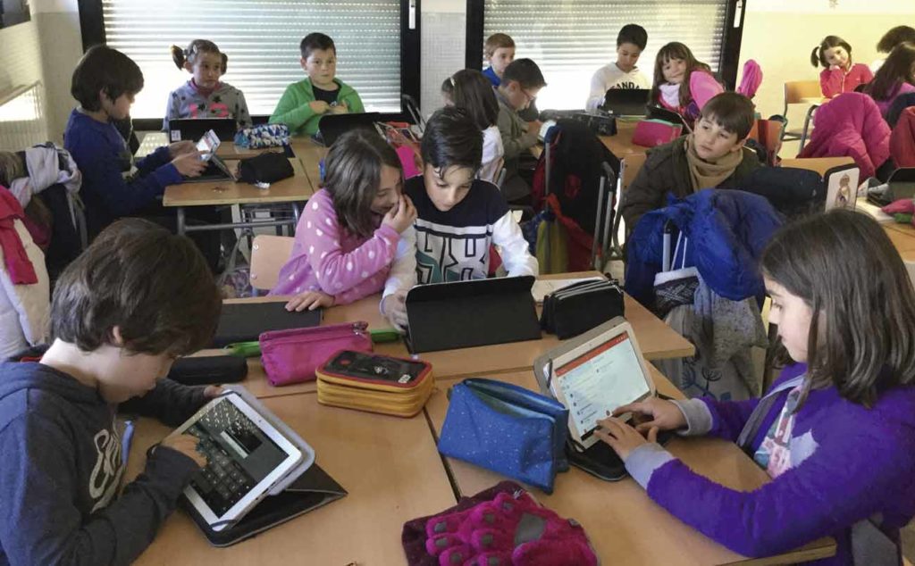 Escolares utilizan tablets para un trabajo de clase. 